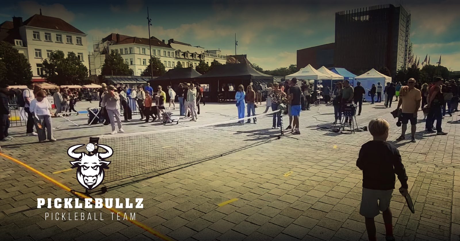 Pickleball spelen op een plein, met het Picklebullz-logo